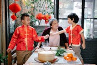 Asian grandmother cooking dumplings with grandsons