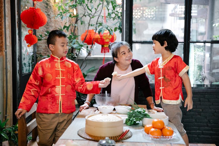 Asian Grandmother Cooking Dumplings With Grandsons