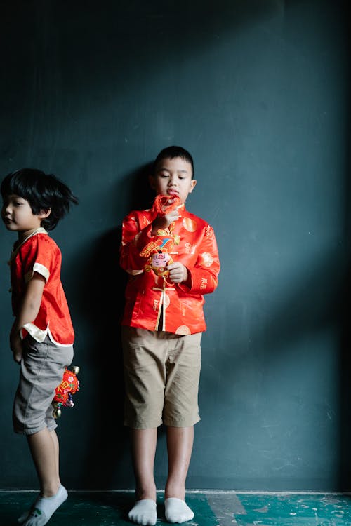 Boys in Red Clothes Holding Chinese Trinkets