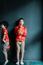Boys in Red Clothes Holding Chinese Trinkets