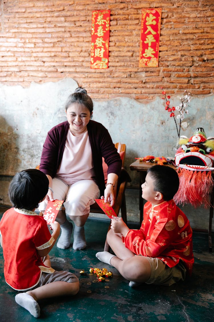 Asian Grandmother Giving Red Envelopes For Children