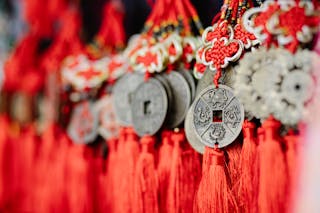 Collection of assorted round amulets in shape of Chinese coins with red satin threads