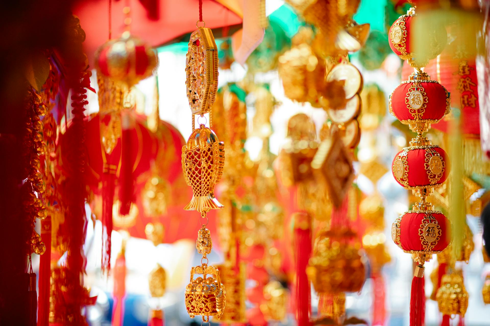 Colorful and ornate Chinese New Year decorations hanging in a festive setting, featuring gold and red elements.