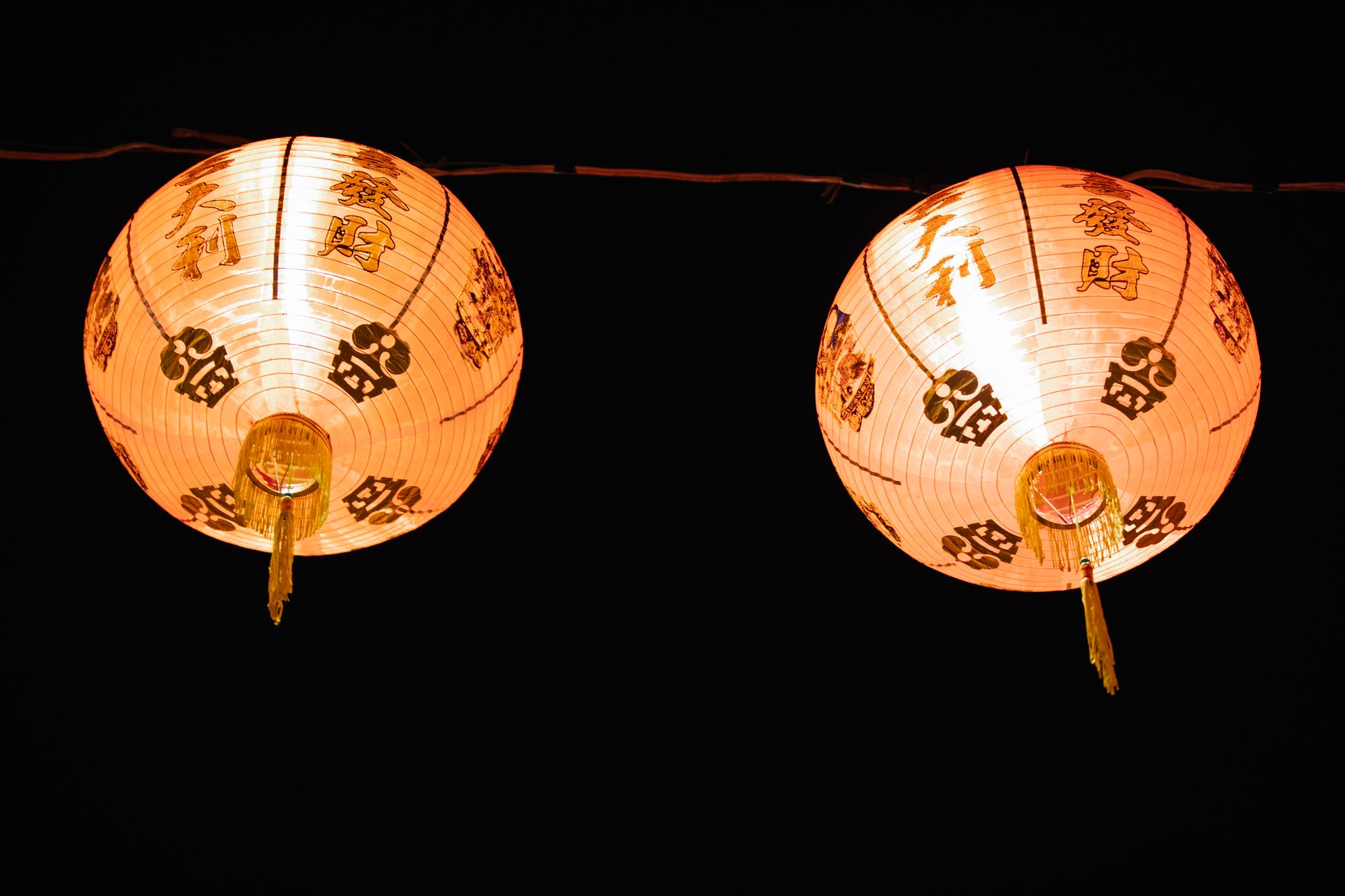Red and gold Chinese lanterns glowing at a night festival celebration