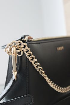 Close-up of a stylish black leather bag featuring a gold chain, perfect for fashion lovers.
