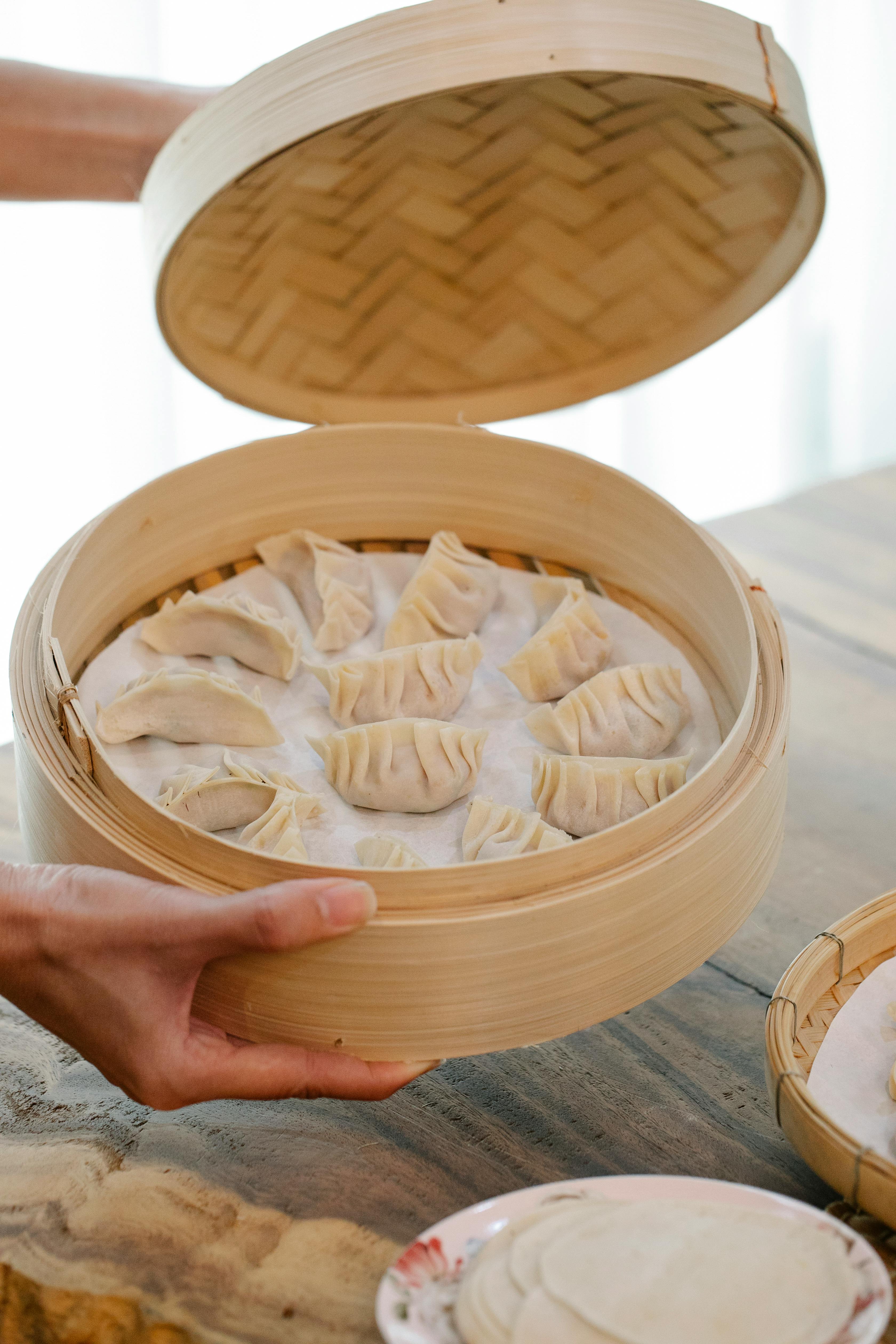 woman with raw dumplings in kitchen