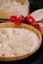 Bamboo tray with raw dumplings near blooming branch