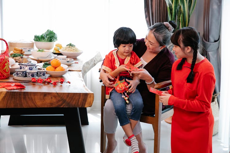 Smiling Ethnic Grandmother Giving Present To Grandson