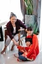 Asian grandmother giving envelop to grandson sitting with sister