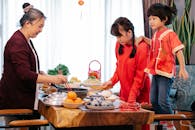 Smiling Asian old woman cooking Chinese food for event