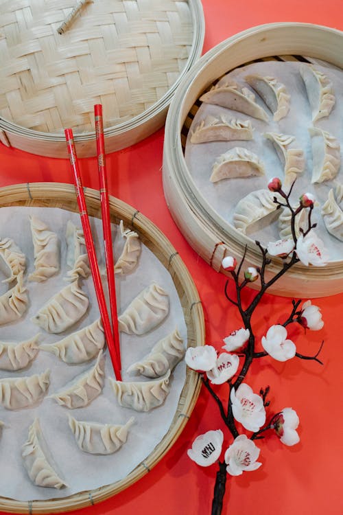 Trays with delicious Asian dumplings with chopsticks placed on table