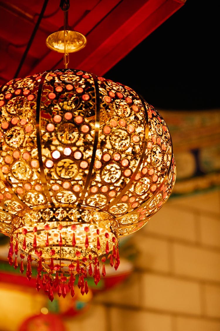 Glowing Carved Metal Lantern Hanging On Street At Night During Traditional Festival