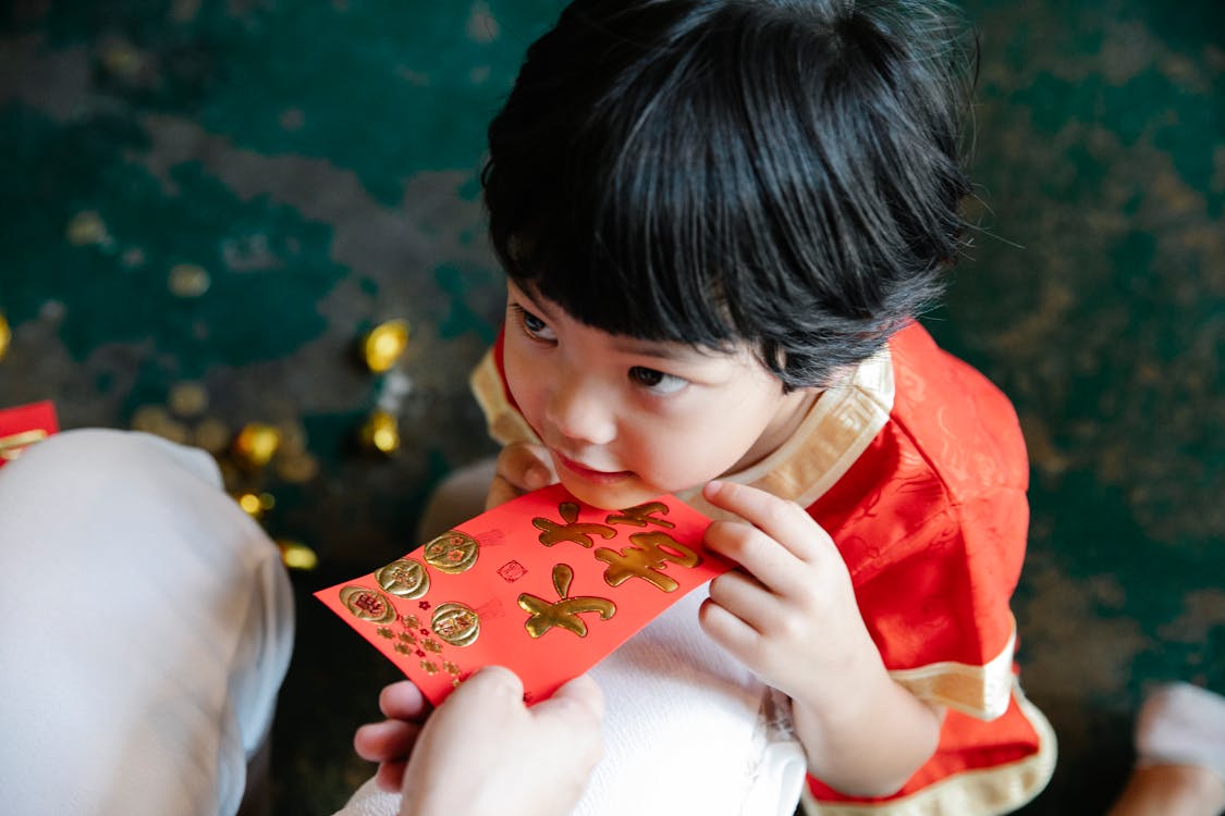 Young child receiving a red envelope during Lunar New Year