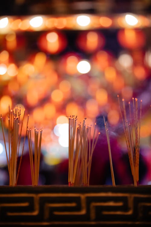 Burning incense sticks on illuminated street during celebration of Chinese New Year at night