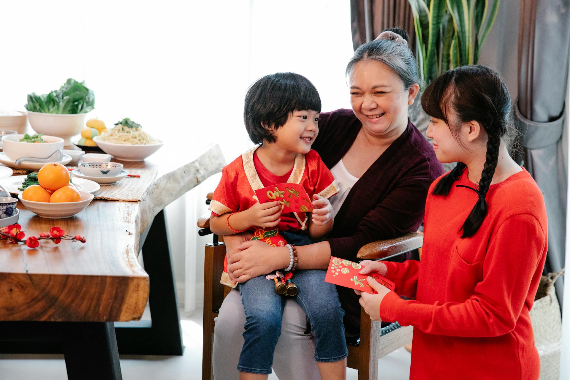 Joyful family sharing red envelopes during Chinese New Year celebration at home.