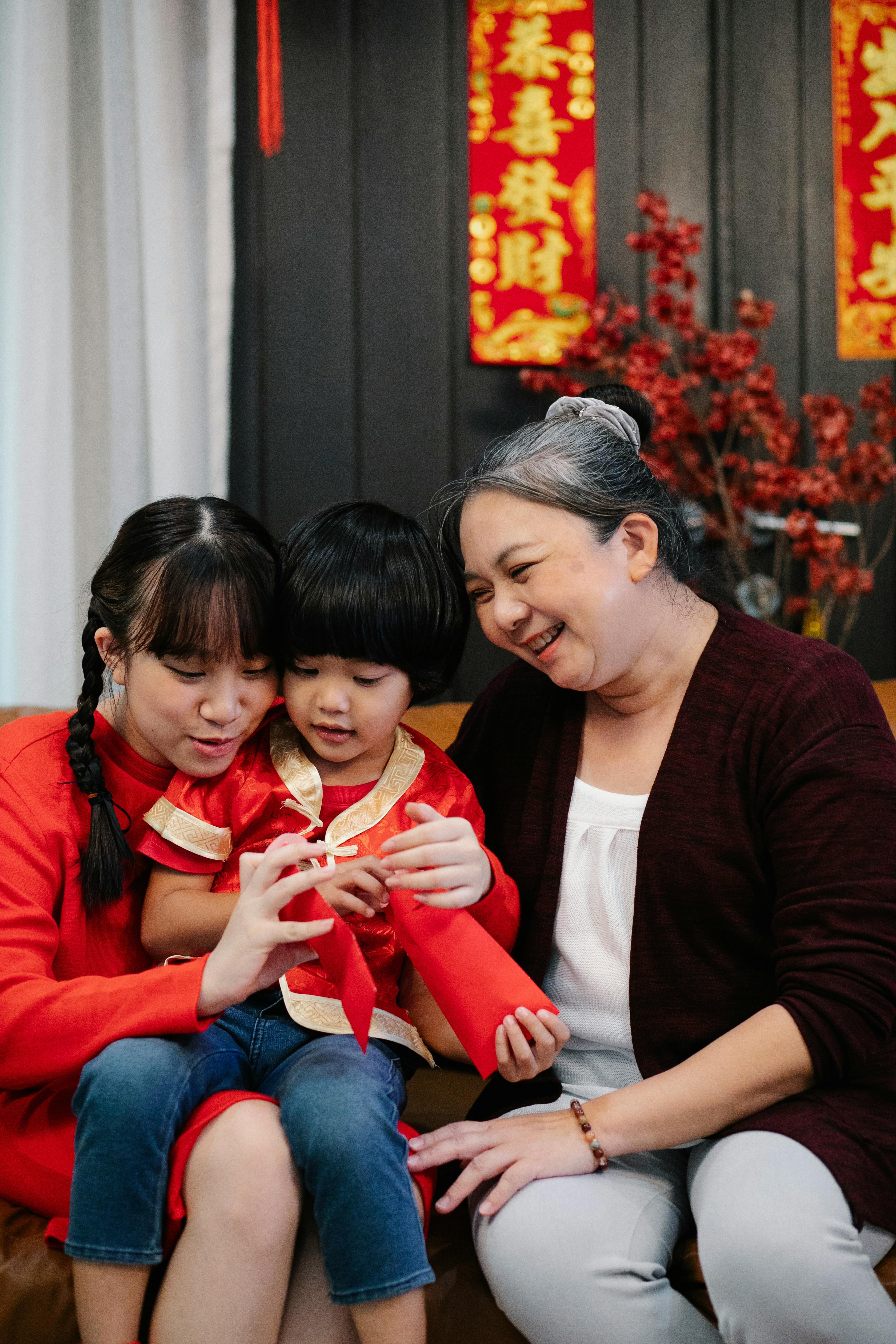 a grandmother sitting on the sofa with her grandchildren