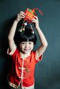 A Boy in Red Clothes Holding a Trinket