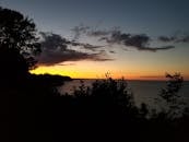 Body of Water Near Trees Under Orange Sunset