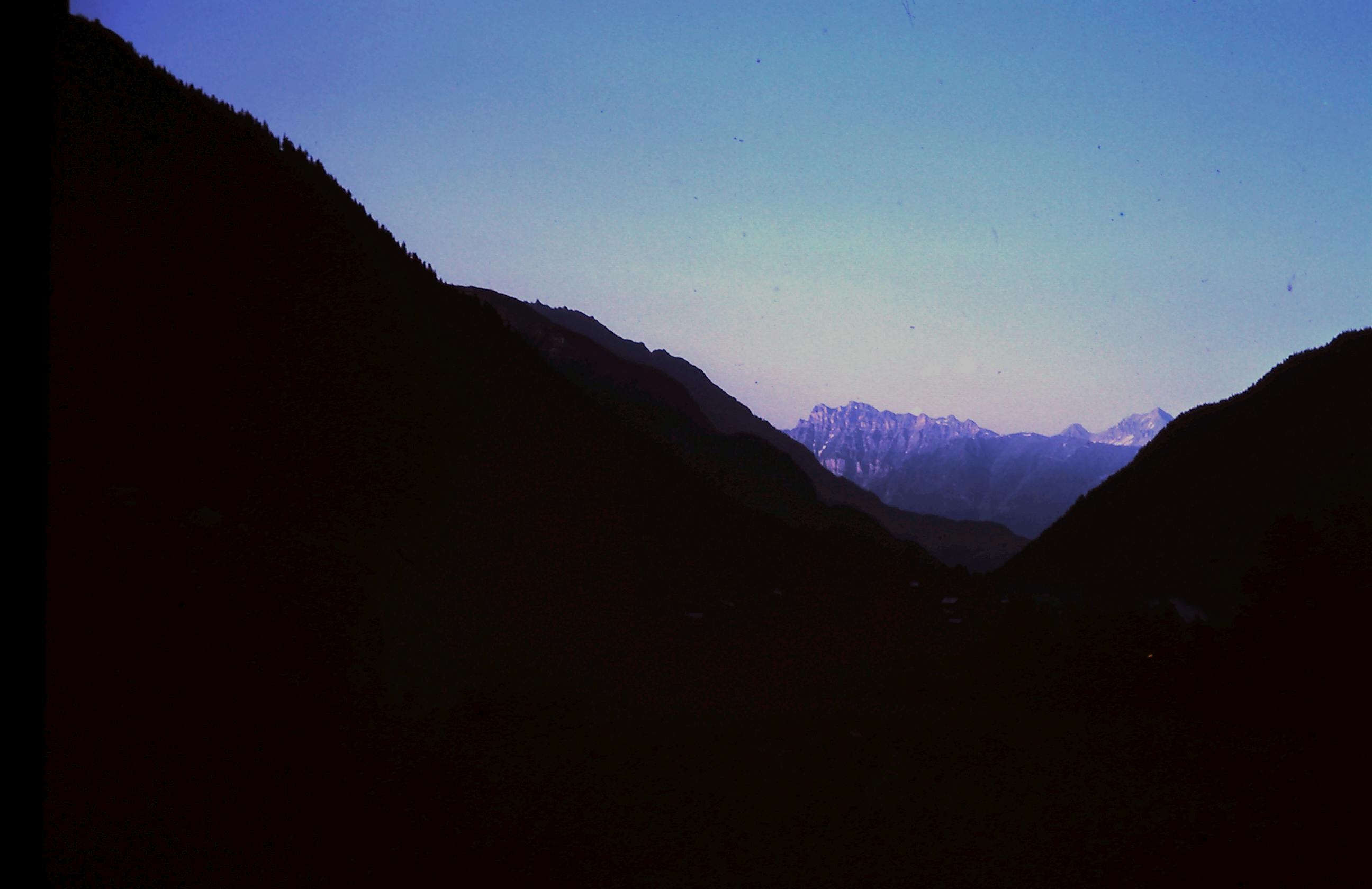 A stunning view of silhouetted mountains under a clear sky at sunset, perfect for nature and travel content.