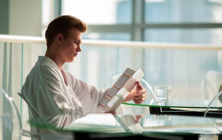 A Man In A Bathrobe Checking The Menu