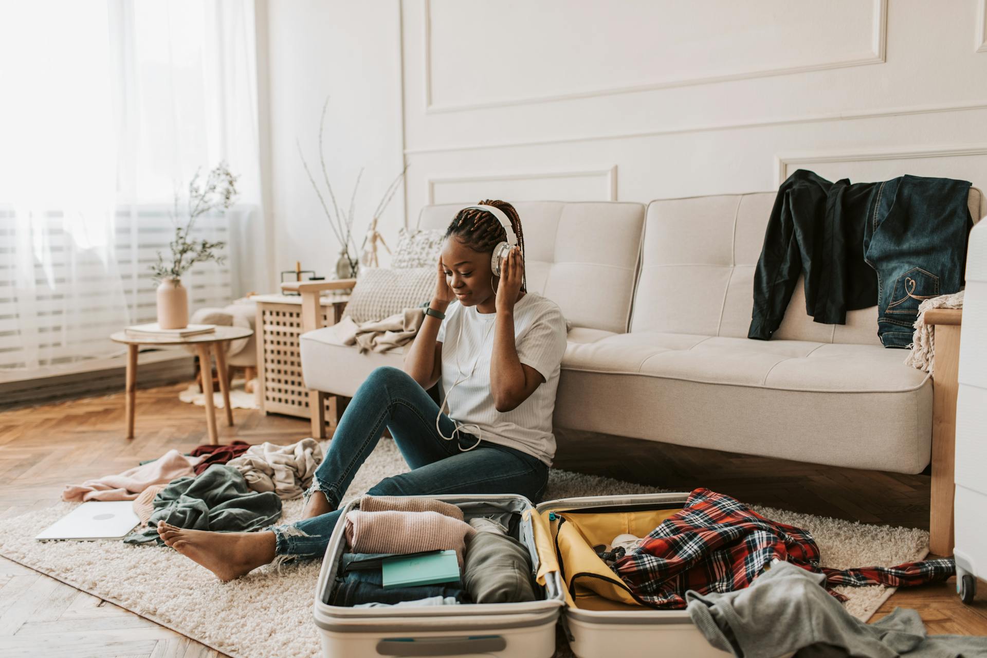 A Woman Listening on Her Headphones while Packing