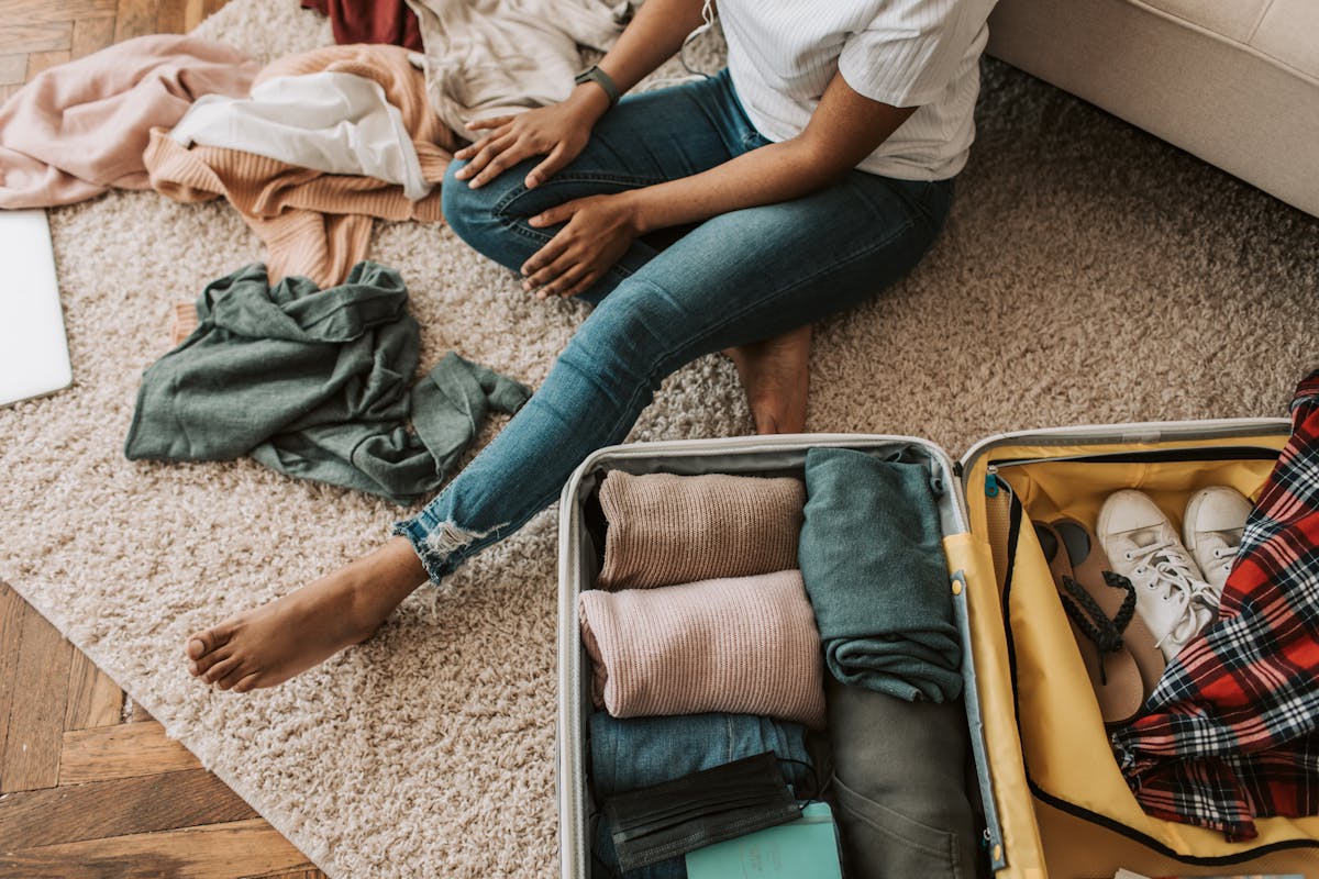 Woman organizing personal items and preparing suitcase for residential treatment stay