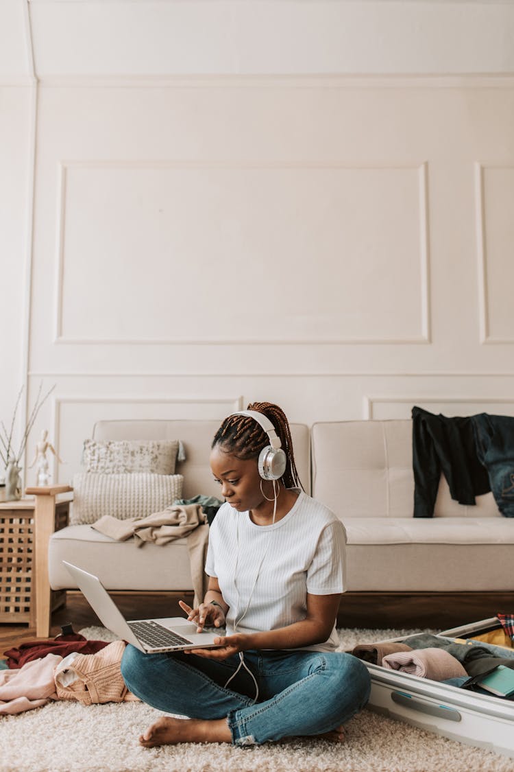 A Woman Wearing Her Headphones And Using Her Laptop