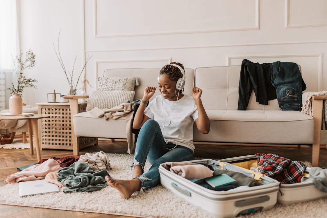 Free A Woman Listening on Her Headphones while Packing Stock Photo