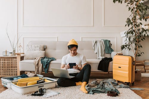Free A Man Using His Laptop in a Messy Living Room Stock Photo