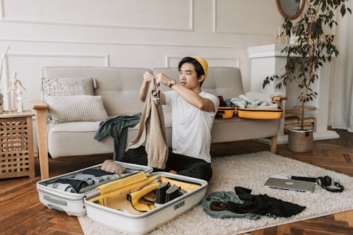 Free A Man Packing Clothes in a Suitcase Stock Photo