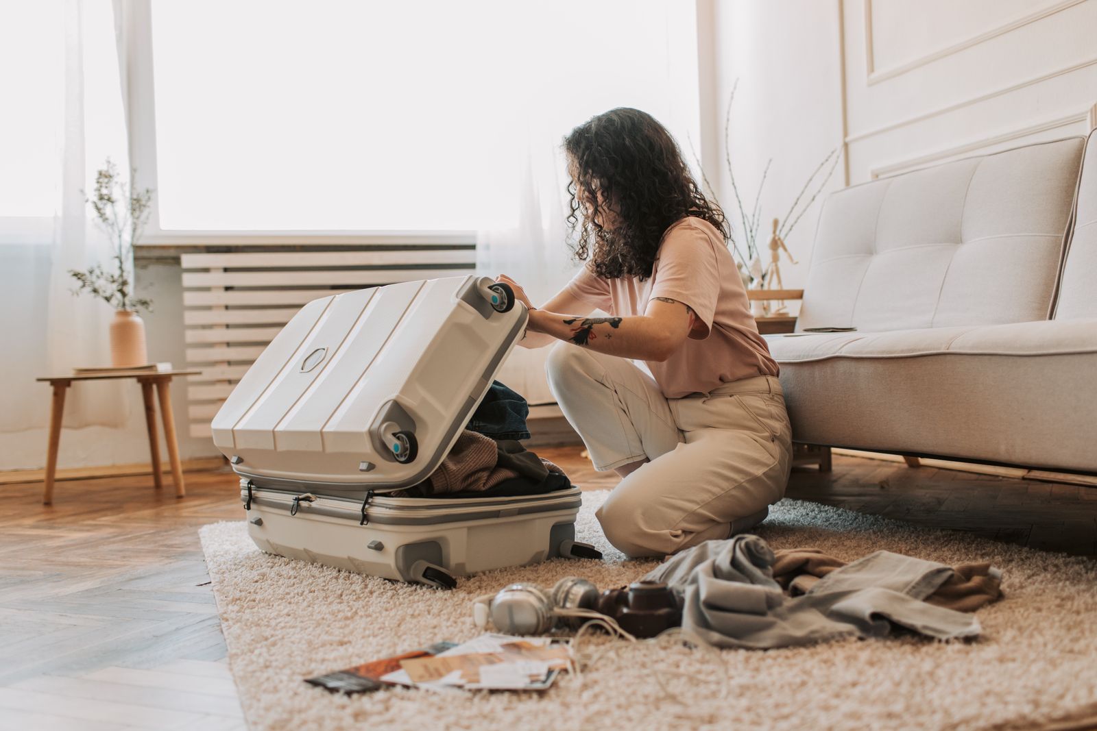 Woman carefully packing her luggage with organized clothes and travel essentials
