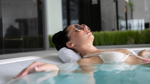 A Woman with Sunglasses Relaxing in a Jacuzzi