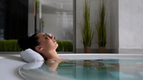 Free A woman relaxes in a jacuzzi with sunglasses, embodying self-care and relaxation. Stock Photo