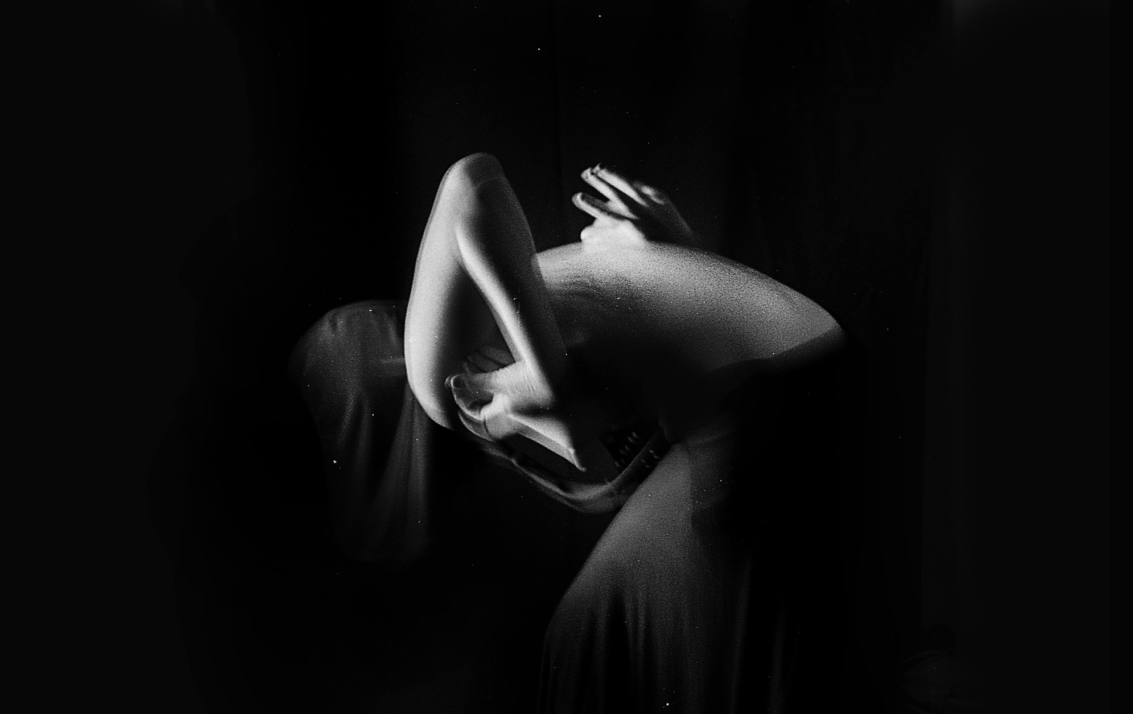 anonymous naked woman dancing gracefully in dark studio