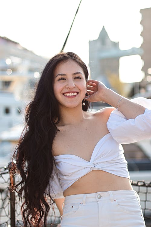Free A Smiling Woman Wearing a White Off Shoulder Shirt  Stock Photo