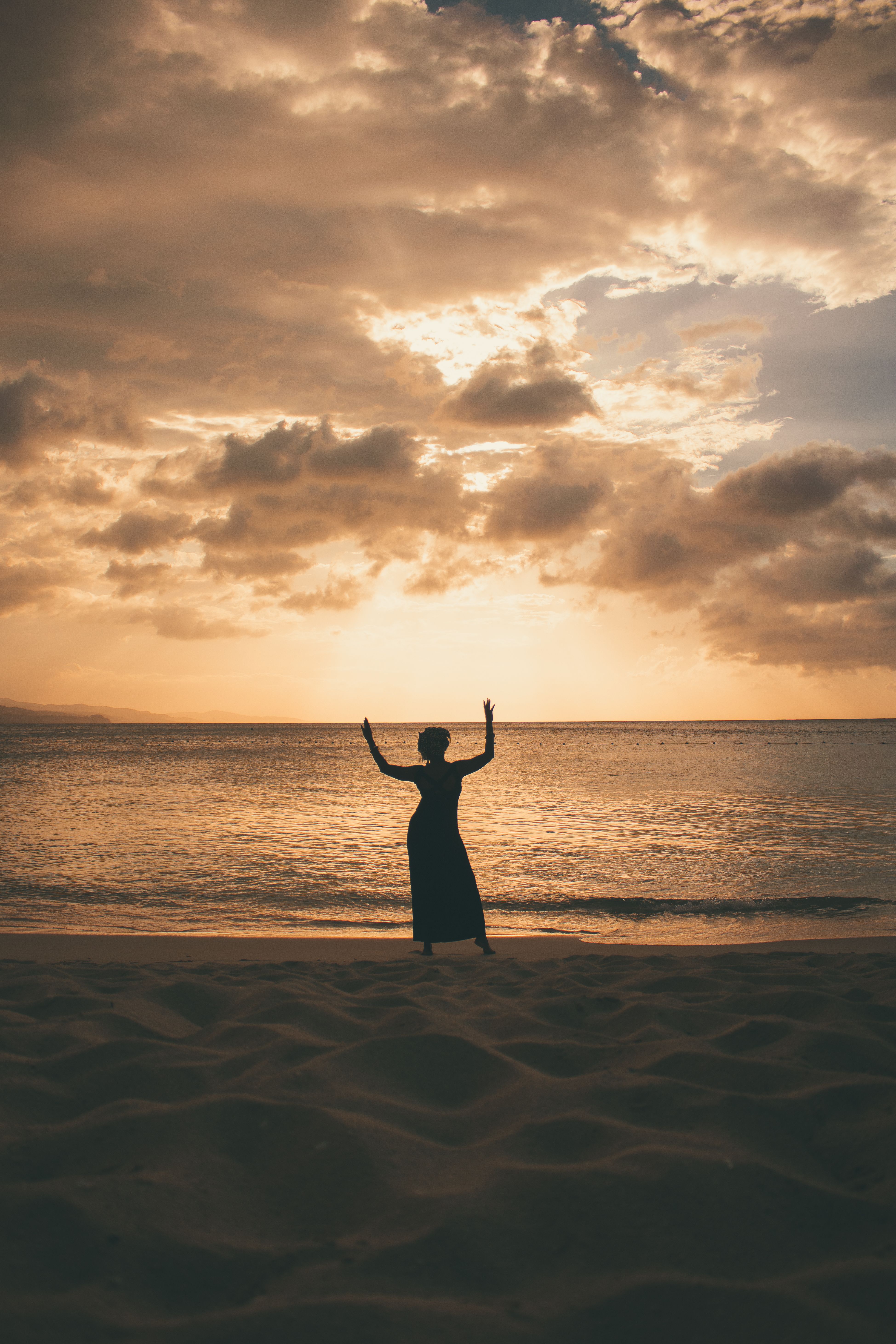 Silhouette of a Woman Posing on the Beach at Sunset · Free Stock Photo