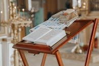 Old wooden analogion with Bible and metal box prepared for christening in church