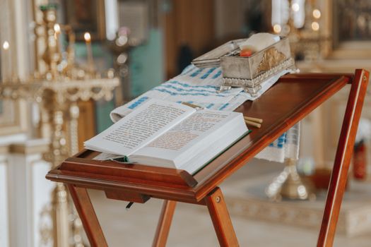 Old wooden analogion with Bible and metal box prepared for christening in church