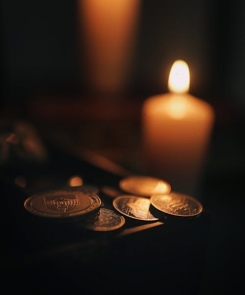 Free Coins beside a Lighted Candle   Stock Photo