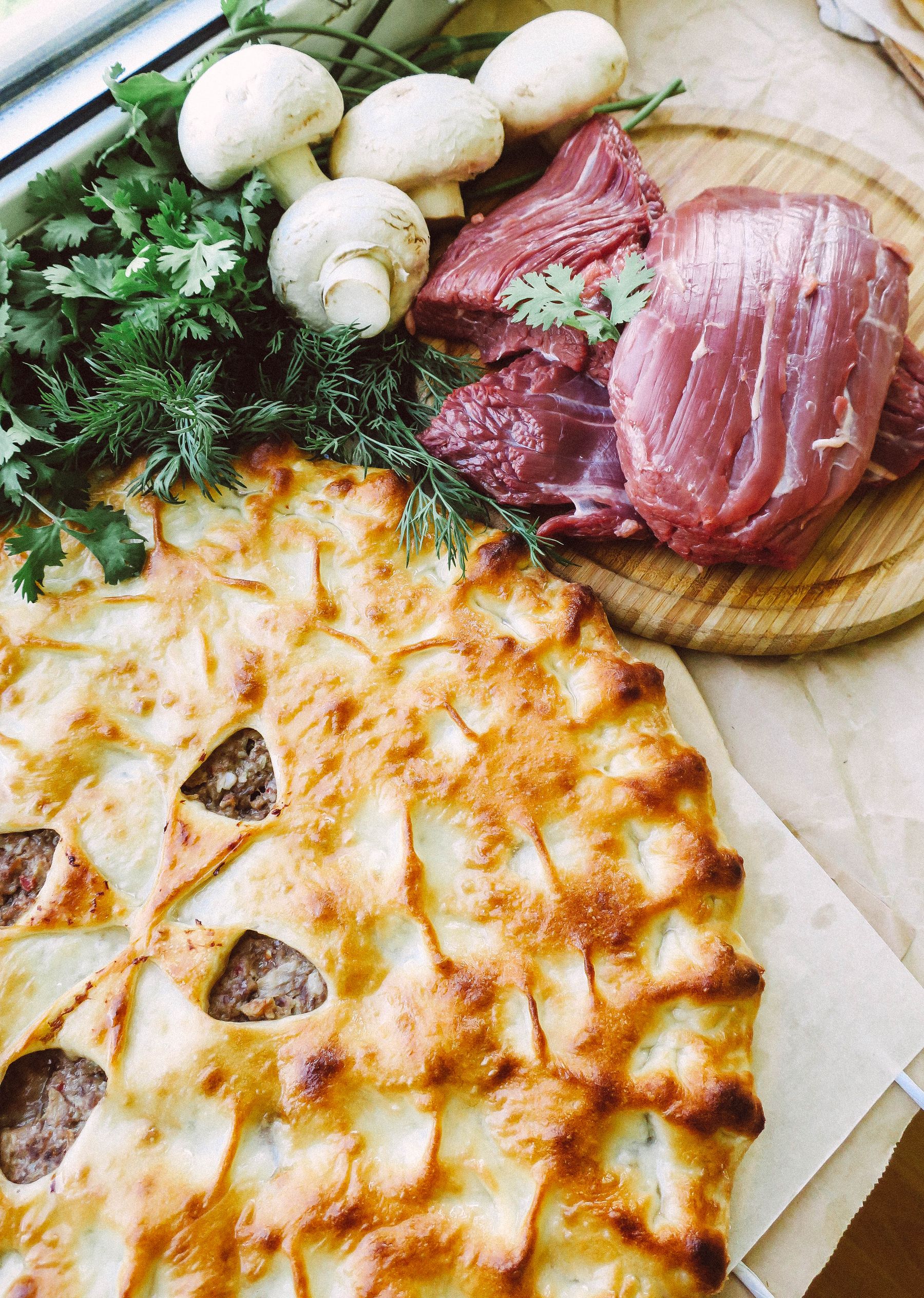 Golden savoury meat pie with mushrooms and fresh herbs