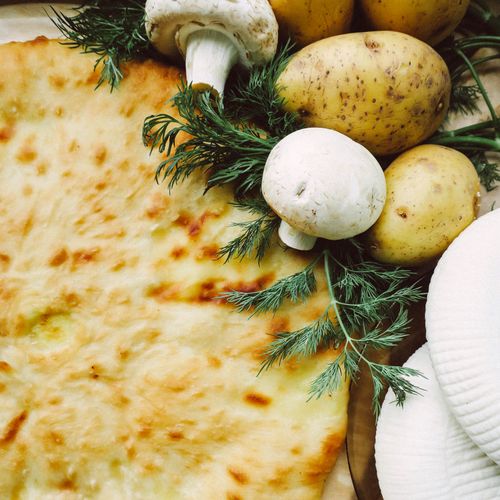 Free Close-up of rustic baked dish with potatoes, mushrooms, and greens. Stock Photo