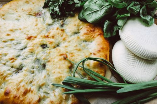 Free Close-up of freshly baked bread with cheese, spinach, and fresh herbs. Stock Photo