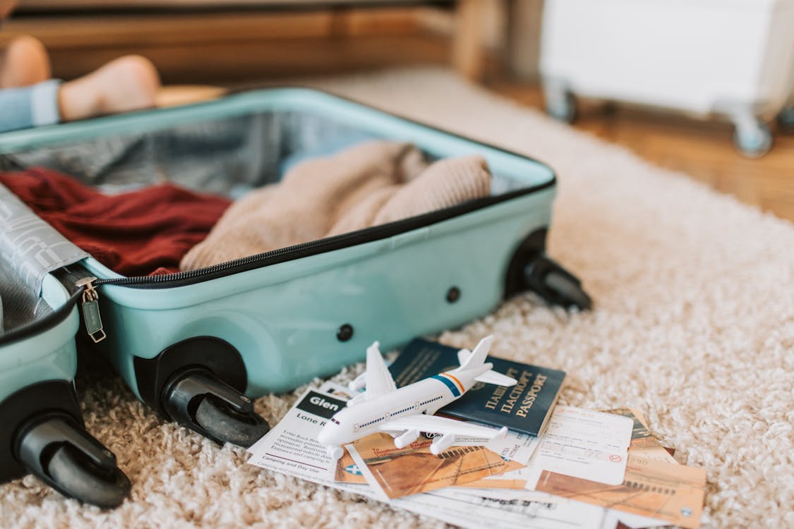 Free Black and Green Luggage Bag on Brown Carpet Stock Photo