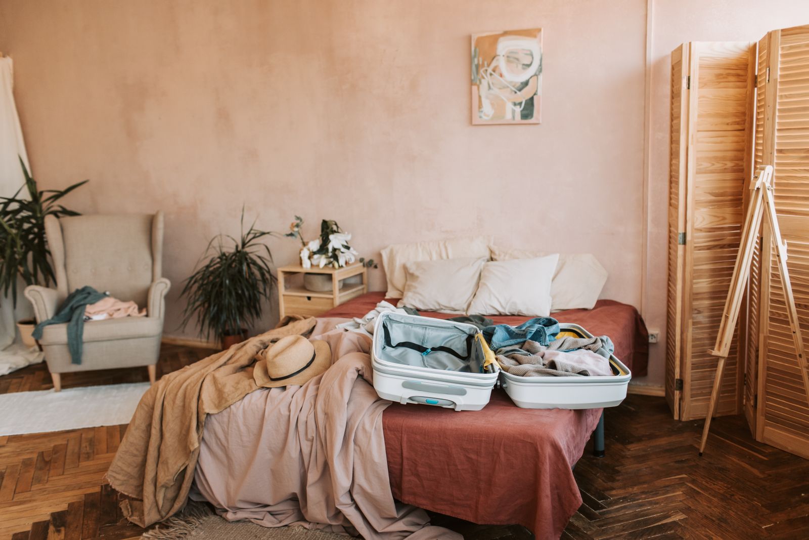 Open travel suitcase prepared on a bed