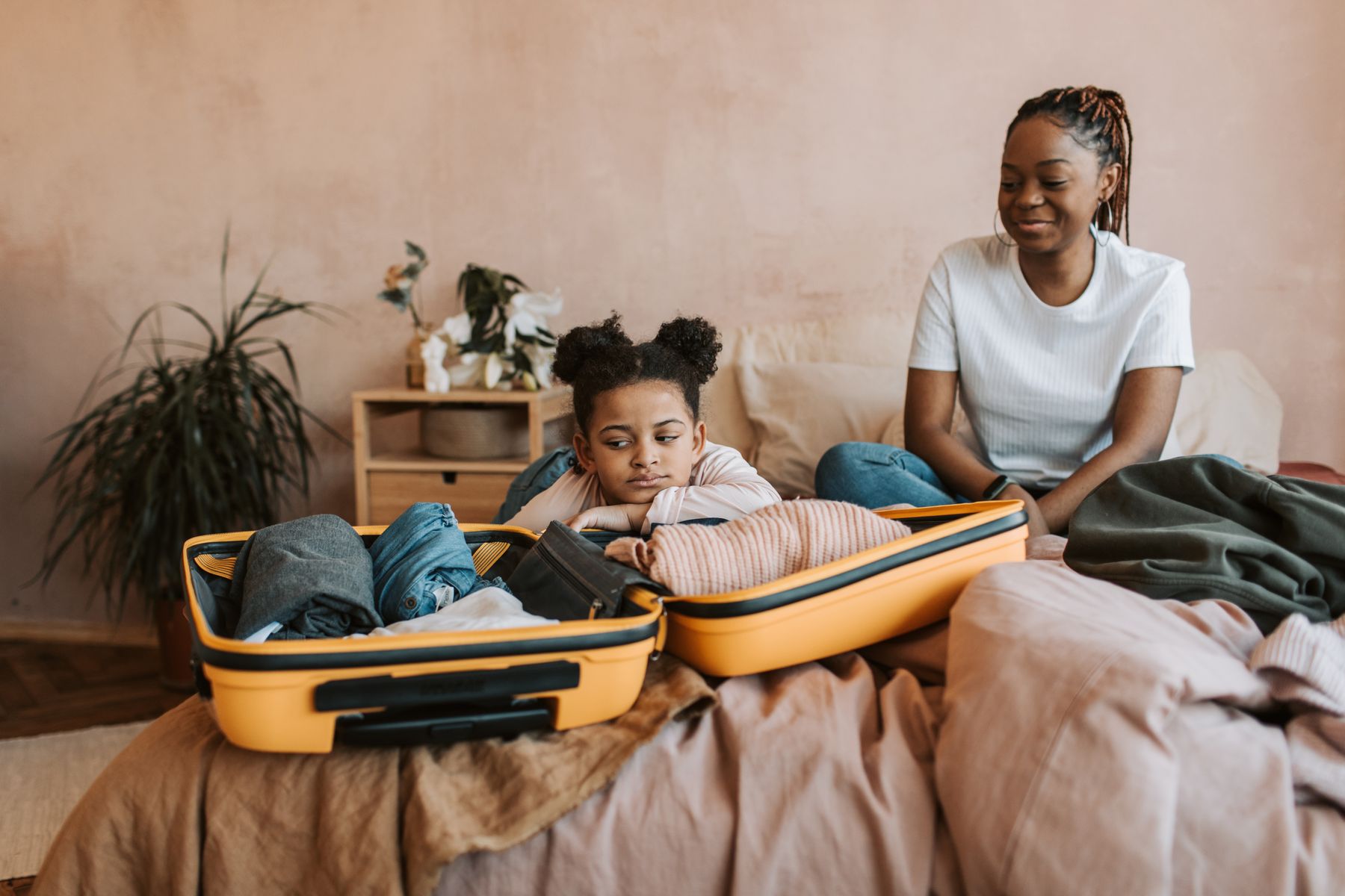 Family packing clothing into a suitcase together for a trip