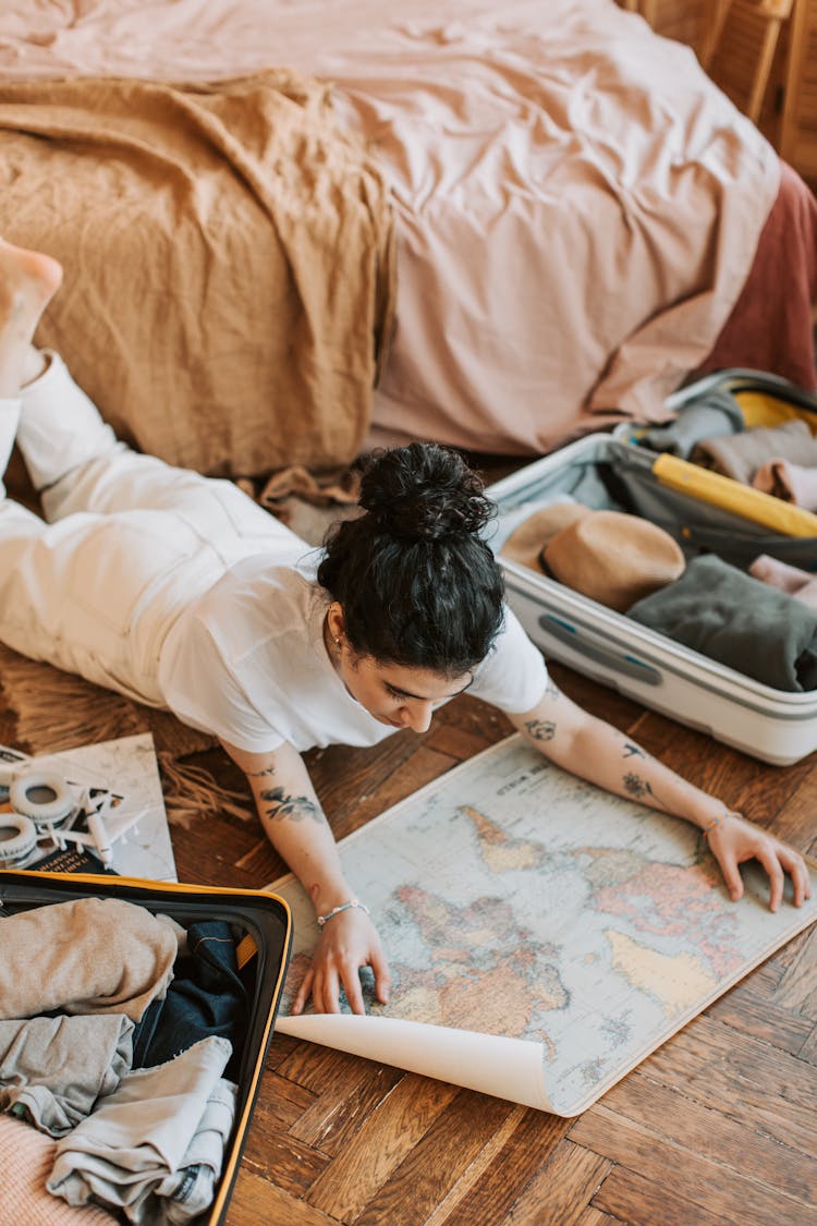 Pretty Woman Lying On The Floor Holding A Map