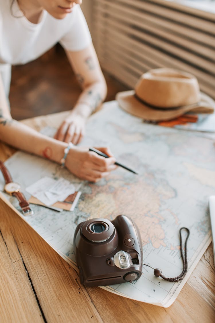 Person Holding Pen Over A Map