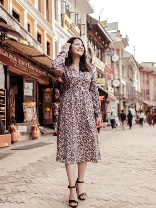 Free An Asian woman joyfully posing and smiling on a lively city street with shops. Stock Photo