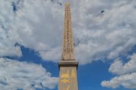 The Luxor Obelisk under a bright blue sky at Place de la Concorde, Paris.