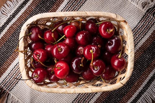 Close-Up Shot of Cherries on a Woven Basket